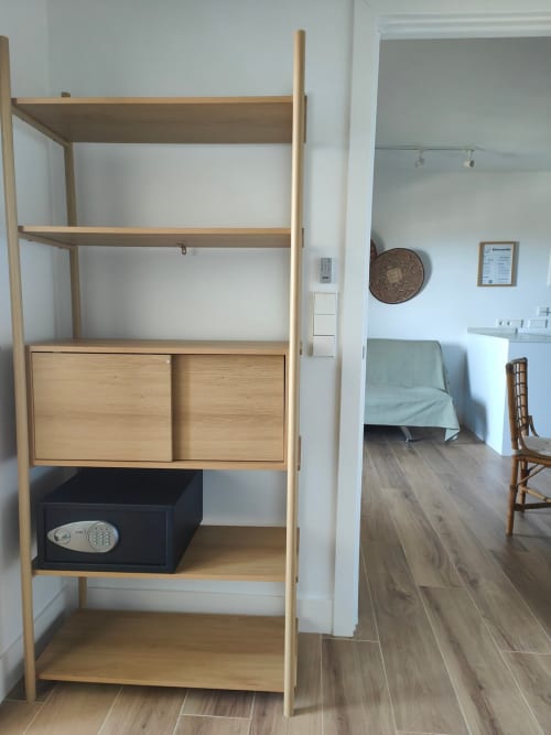 Wooden shelving unit with storage in Nido Anaga apartment, Santa Cruz de Tenerife, showing bedroom and furniture beyond
