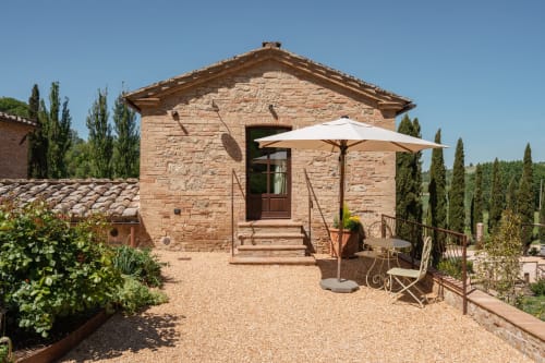 Stone cottage with white umbrella at Agriturismo La Frattina, Buonconvento, Siena