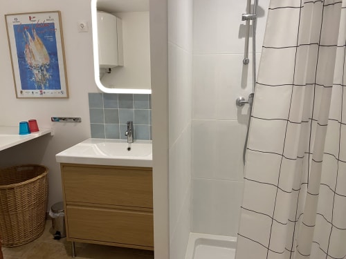 Salle de bain moderne de la villa Le Mas Bello Visto à Lorgues avec vanité en bois, douche et dosseret carrelé