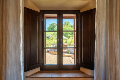 Dark wooden French doors opening to Tuscan countryside at Agriturismo La Frattina, Siena