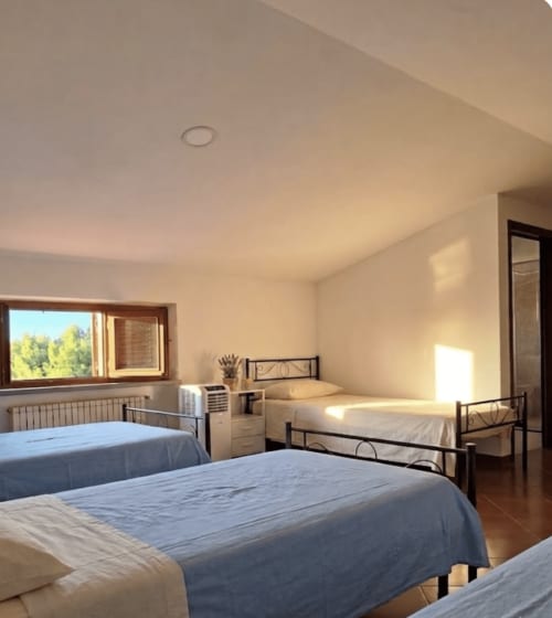 Bright male dormitory room at B&B Rio Grande hostel in Massarosa with multiple beds and natural light