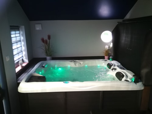 Bain à remous luxueux aux eaux lumineuses vertes et éclairages LED à la spa Au Repos De La Licorne, Gommegnies