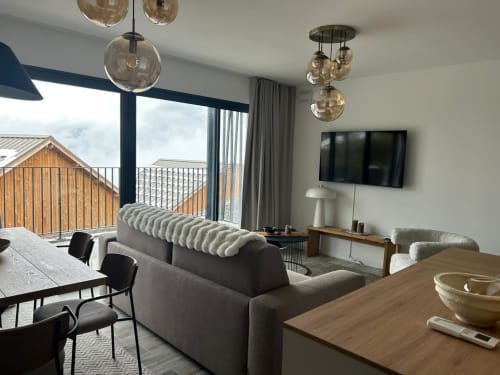 Appartement moderne CIRELINE-La Fontaine du Roy à Rognes avec vue montagne, mobilier contemporain et luminaires suspendus.