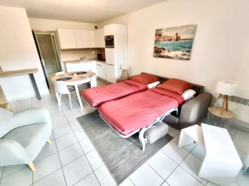 Studio Malibu Catalan T2 à Barcaresa, Port Leucate : canapé-lit rouge, kitchenette, coin repas, ambiance méditerranéenne