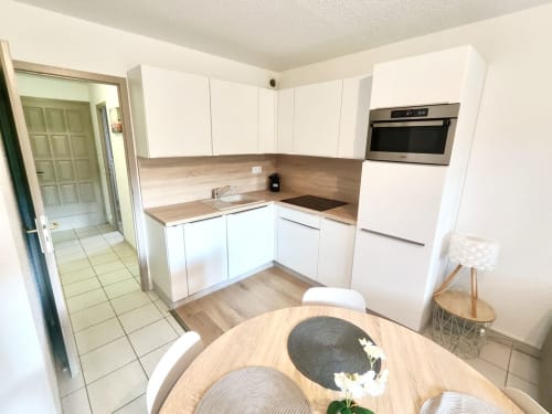 Cuisine moderne avec armoires blanches et comptoirs en bois dans l'appartement Barcaresa, Port Leucate
