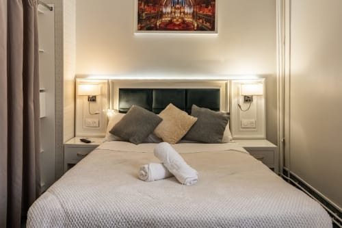 Camera moderna dell'Hotel Royal Paris Ivry con letto queen, testata grigia e illuminazione contemporanea