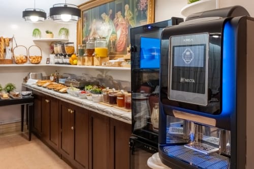 Moderner Frühstücksbereich mit Krea Necta Kaffeemaschine, Gebäck und Getränken im Hotel Royal Paris Ivry