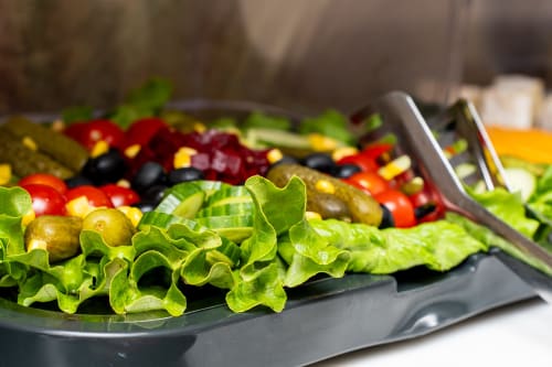 Frischer Salat mit Kopfsalat, Oliven, roten Paprika und Kapern im Restaurant des Hotel Royal Paris Ivry
