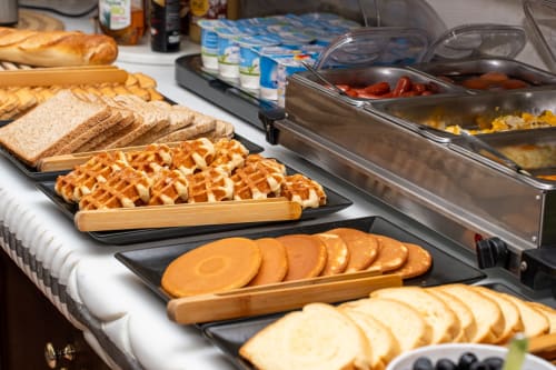 Frühstücksbuffet des Hotel Royal Paris Ivry mit Waffeln, Scheibenbrot, Gebäck und frischem Obst.