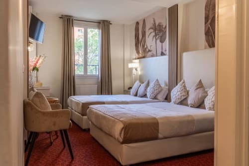 Due letti singoli in spaziosa camera dell'Hotel Royal Paris Ivry con elegante arredamento, parete specchiata e vista sulla città
