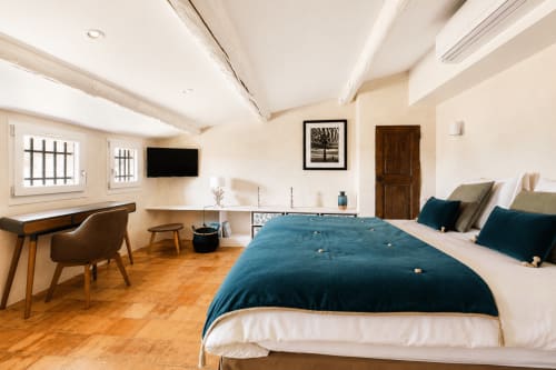 Suite Sainte Victoire bedroom at Les Suites de Montigny, Aix-en-Provence, with blue bed, desk, TV, and wooden floor
