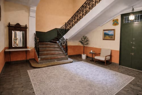 Elegant lobby of Suite Sainte Victoire apartment in Aix-en-Provence with staircase and ornate railing