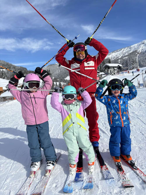 Ski instructor and children holding skis at Chez Francine resort in Notre Dame de Bellecombe, France