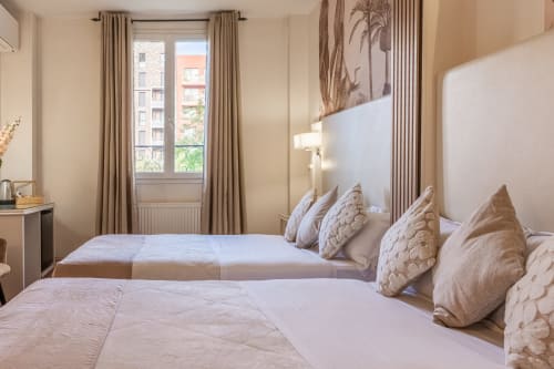 Elegante camera twin all'Hotel Royal Paris Ivry con arredamento beige, due letti e vista parigina