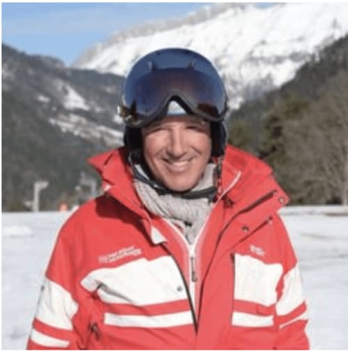 Smiling ski instructor in red jacket with blue goggles at Chez Francine, Notre Dame de Bellecombe, French Alps