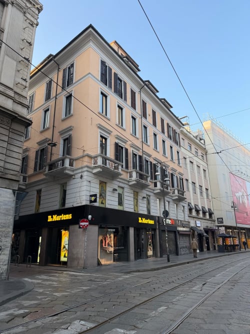 Maisons Milano building exterior on Via Dei Piatti, Milan - modern apartment hotel with peach and white facade, ground floor