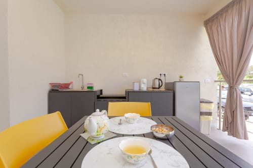 Modern dining area with yellow chairs at Le Dune Relax hotel in San Teodoro, Italy, overlooking the pool
