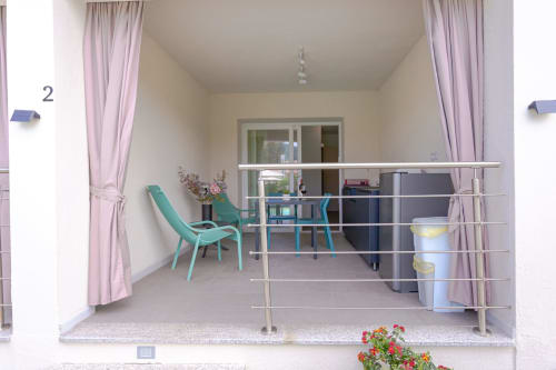 Modern hotel room balcony at Le Dune Relax, San Teodoro with turquoise chair and pool view