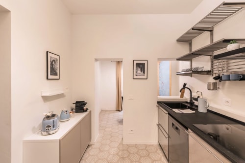 Cucina moderna della Casa Vacanze di Flavia a Roma con elettrodomestici in acciaio inox, mensole a vista e arredamento neutro