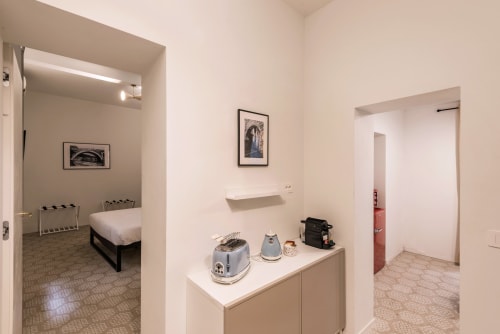 Flavia's Holiday Home Roma: ingresso moderno con angolo cottura, opere d'arte incorniciate e accessi a camere e zona living