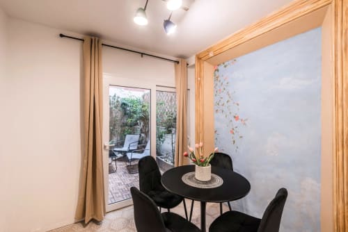 Tavolo rotondo nero con sedie nella zona pranzo di una casa vacanze a Roma, che si apre sul giardino
