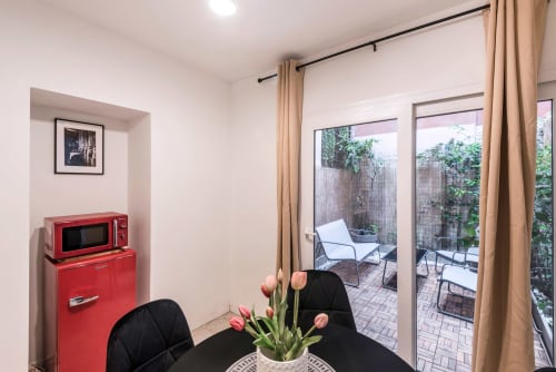 Angolo cottura moderno con elettrodomestici rossi retrò e zona pranzo a Flavia's Holiday Home a Roma, con accesso al patio