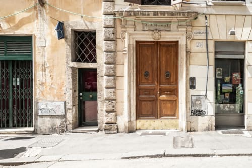 Facciata storica di edificio romano con porte in legno e muri color crema invecchiati, ingresso alla casa vacanza Flavia