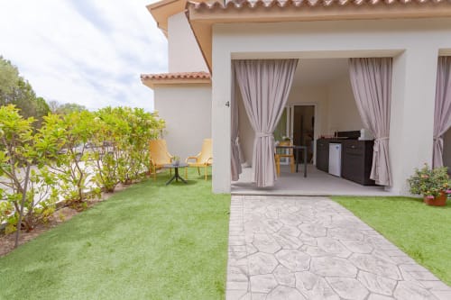 Le Dune Relax King deluxe room garden view with patio, lawn, and furnished terrace in San Teodoro