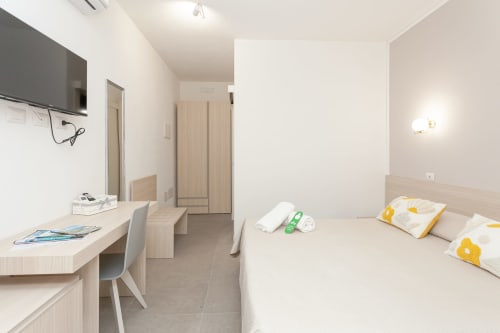 King deluxe room at Le Dune Relax, San Teodoro with bed, desk, TV, and garden view