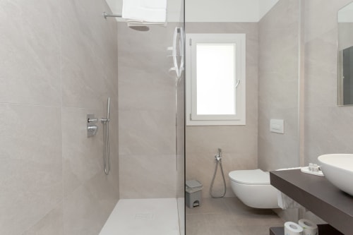 Modern bathroom with walk-in shower, toilet, and vanity sink at Le Dune Relax hotel in San Teodoro