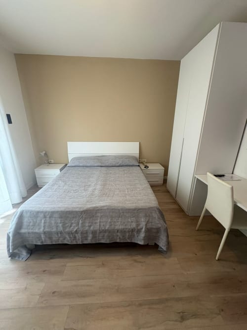 Modern bedroom at Hotel Panorama Lido di Jesolo with queen bed, white nightstands, wardrobe, and wooden flooring