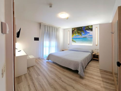 Modern hotel bedroom at Hotel Panorama Lido di Jesolo with sea view artwork, king bed, balcony access, and contemporary