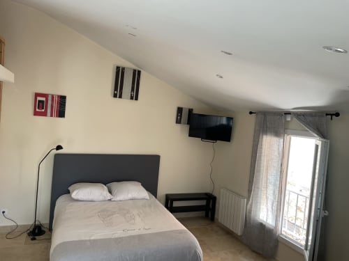 Chambre studio à l'Hôtel d'Albion à Sault avec lit, TV murale et portes-fenêtres donnant sur les montagnes
