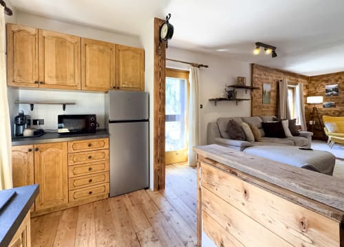 Appartamento in montagna ad Auronzo di Cadore con cucina in legno, zona living e camera da letto con arredi rustici