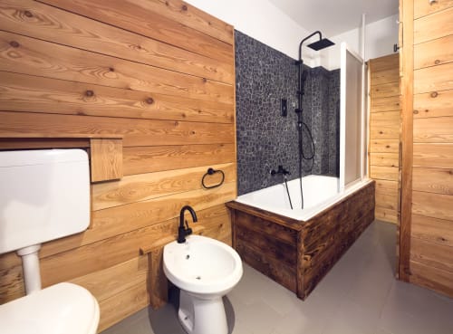 Bagno moderno con pareti in legno, lavabo rotondo e doccia a pioggia nell'appartamento in montagna ad Auronzo di Cadore