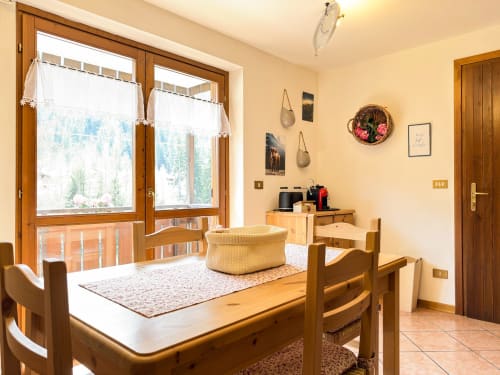 Accogliente stanza di montagna ad Auronzo di Cadore con arredamenti in legno, angolo cottura, zona pranzo e vista alpina dalle ampie finestre