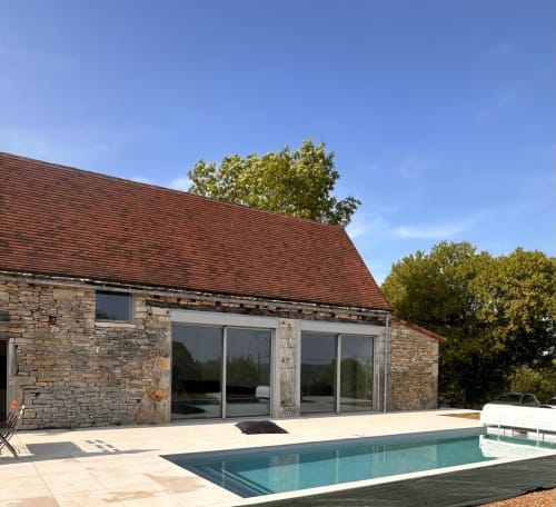 Maison en pierre avec toit rouge, portes vitrées et piscine moderne au Gîte l'Harmonie du Causse, France