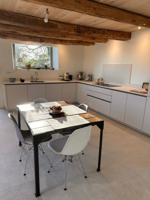 Cuisine moderne avec table à manger au Gîte l'Harmonie du Causse, poutres en bois et lumière naturelle abondante