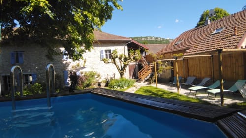 Swimming pool at Maison Maliga B&B in Saint-Pierre-de-Curtille, France with stone buildings