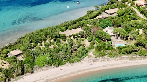 Vue aérienne du resort balnéaire Les Villas d'A Storia à Porto-Vecchio, avec ses eaux turquoise et sa végétation luxuriante
