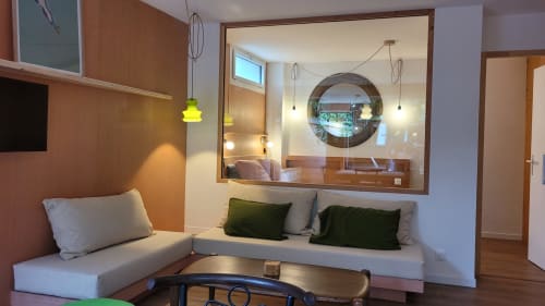 Modernes Studio im Lodge du Cap Ferret mit L-förmigem Sofa, rundem Spiegel, Pendelleuchten und Gartenblick