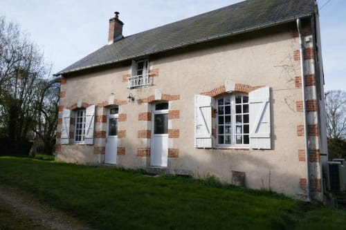 La Jonchere gatehouse villa in Concressault with cream facade, red brick details, white shutters, and manicured garden