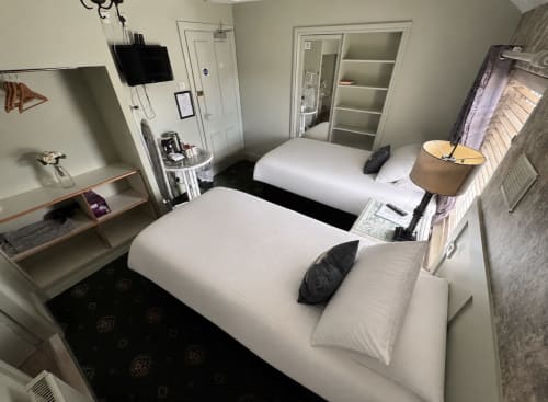 Standard Twin Room at Gwesty Holland Hotel in Holyhead with two beds, TV, desk, and en-suite bathroom