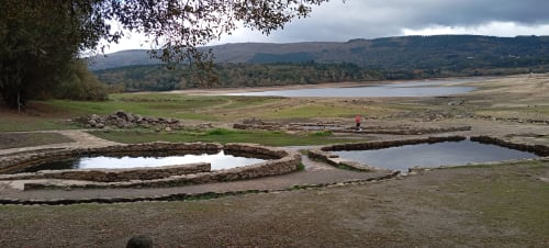 Piscinas rústicas de madera en paisaje herboso con vistas al río en Aldea Rural Santo André, Ourense