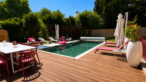 Espace piscine de la Villa Avril & Spa à Sélestat avec terrasse bois, chaises longues et tables de restaurant