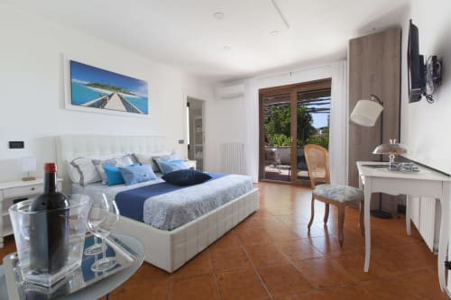 Suite di lusso con vista mare a Villa Iaccarino, Massa Lubrense, con letto bianco, porte sulla terrazza e design moderno