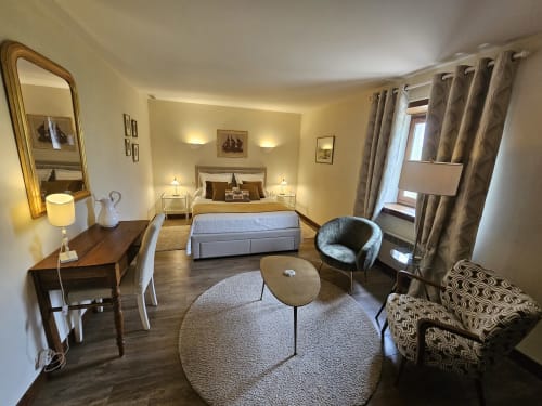 Elegant bedroom suite at Château de Ribourdin with queen bed, sitting area, and garden views