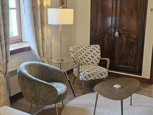 Elegant sitting area at Château de Ribourdin with modern chairs, lamp, and side table in Chevannes