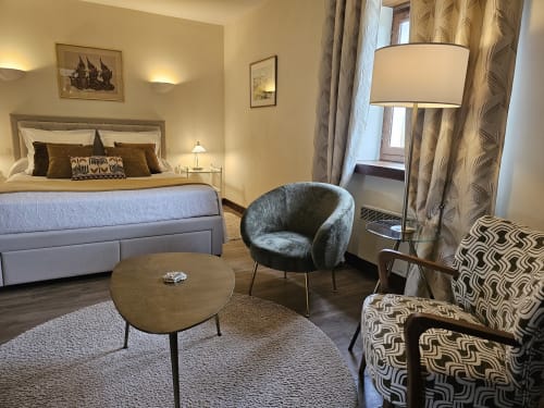 Elegant bedroom at Château de Ribourdin with bed, seating area, and garden view in Chevannes