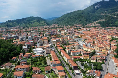 Vista aerea della valle di Medellín circondata dalle montagne, con edifici dai tetti rossi e colline verdeggianti